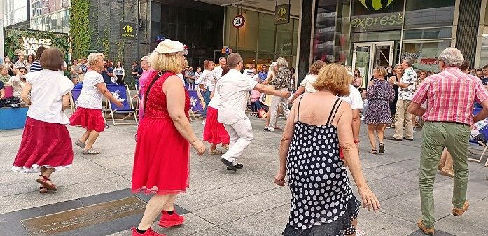 Grupa seniorów tańczy w przestrzeni miejskiej
