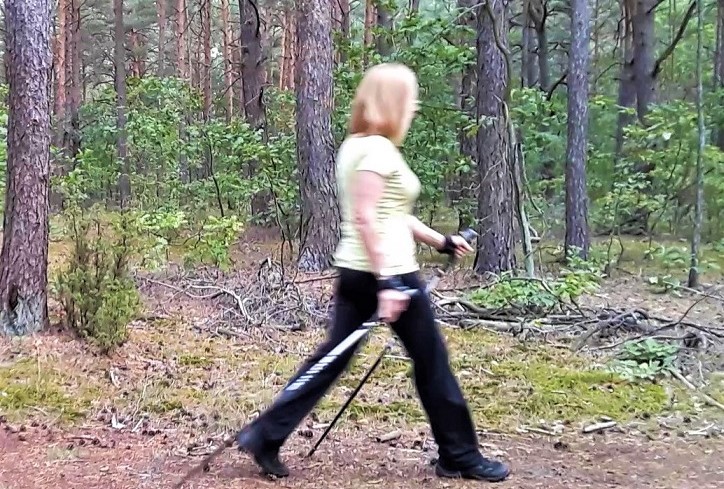 kobieta maszeruje z kijkami nordic walking las spacer